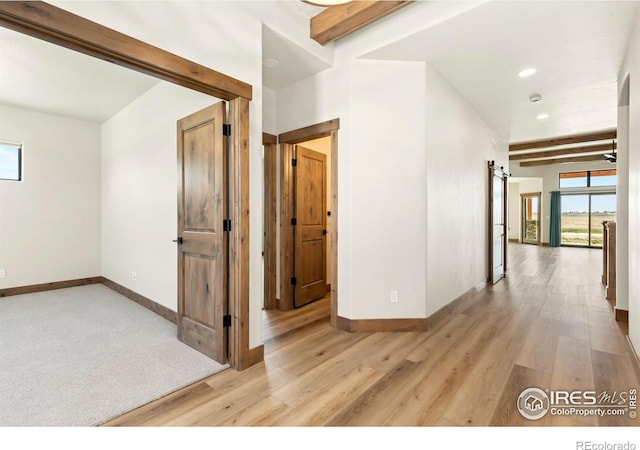 hallway with light wood-type flooring, beam ceiling, baseboards, and recessed lighting