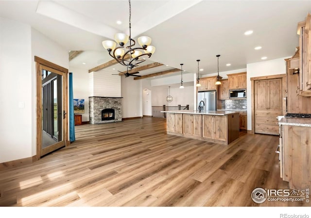kitchen with stainless steel fridge, a notable chandelier, open floor plan, recessed lighting, and built in microwave