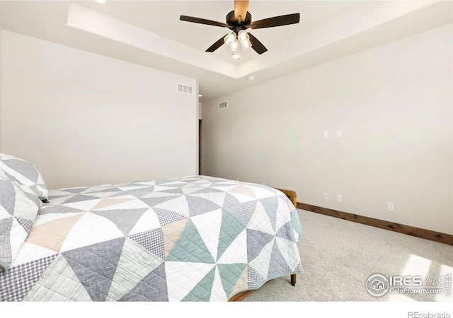 bedroom featuring a raised ceiling, carpet flooring, baseboards, and visible vents
