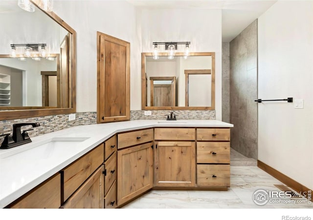 bathroom with double vanity, marble finish floor, a sink, and backsplash
