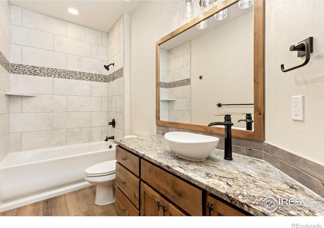 full bathroom featuring washtub / shower combination, vanity, recessed lighting, toilet, and wood finished floors