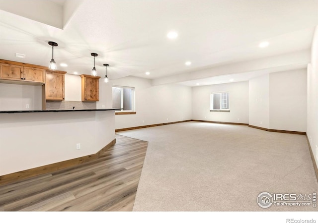 unfurnished living room with light wood-type flooring, baseboards, and recessed lighting