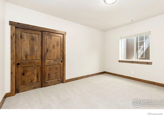 empty room featuring visible vents, baseboards, and carpet floors