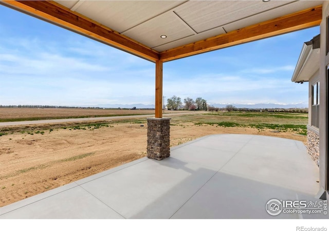 view of patio / terrace with a mountain view and a rural view