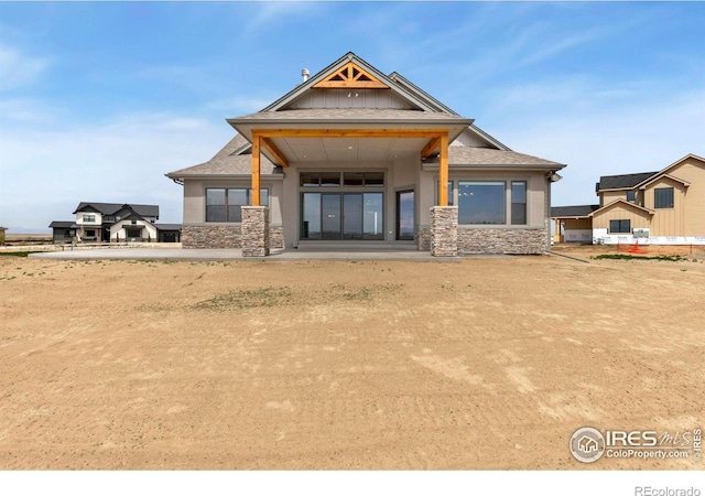 exterior space featuring stucco siding and stone siding