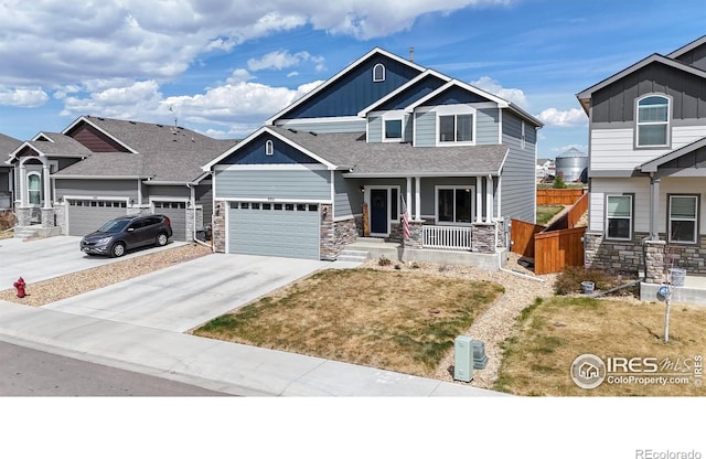 craftsman inspired home featuring stone siding, a porch, board and batten siding, and a garage