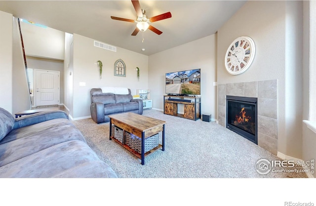 living room featuring a fireplace, carpet floors, visible vents, and ceiling fan