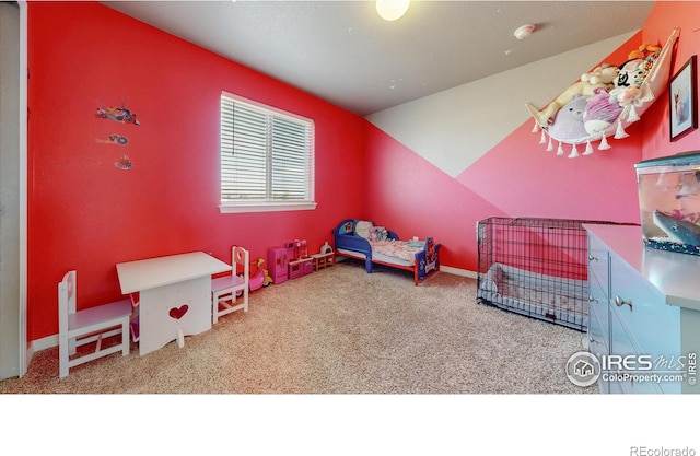 carpeted bedroom with lofted ceiling and baseboards