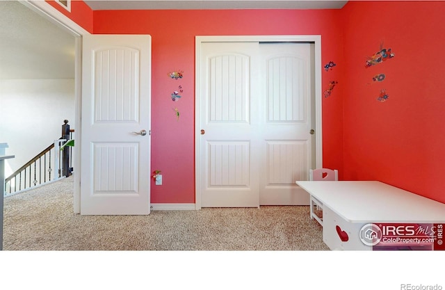 bedroom featuring baseboards, carpet, and a closet