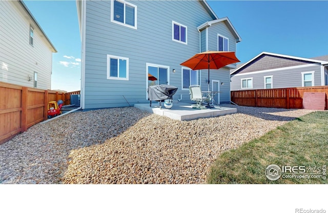 rear view of property featuring central air condition unit, a patio area, and a fenced backyard