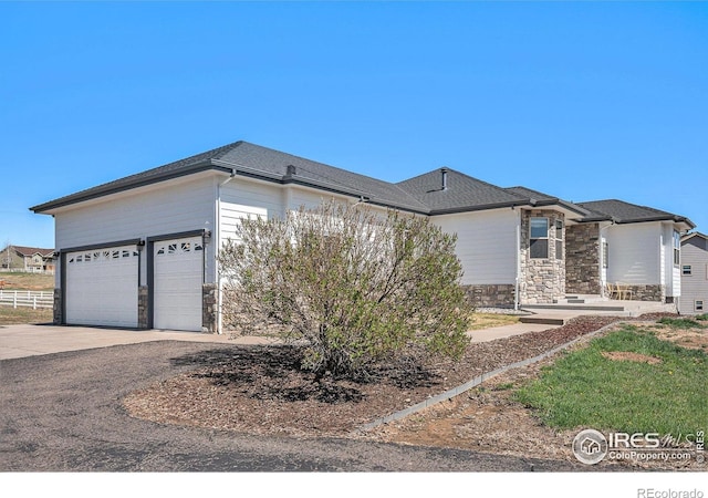 view of front of house with stone siding, an attached garage, and concrete driveway