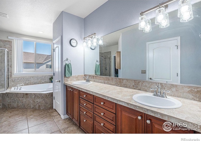 full bath with a garden tub, a sink, double vanity, and a stall shower
