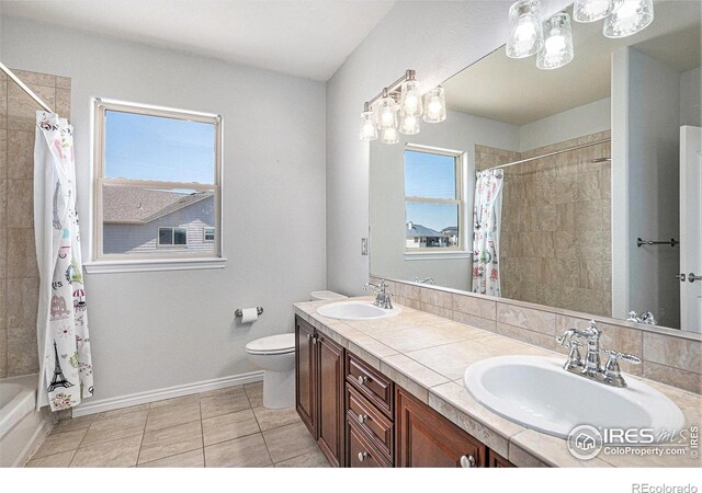 bathroom featuring tiled shower / bath, tile patterned floors, toilet, and a sink