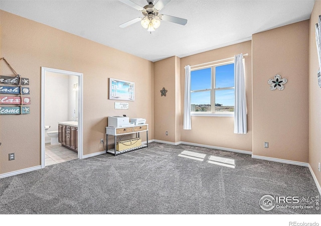 carpeted bedroom featuring baseboards and connected bathroom