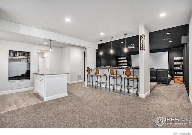 kitchen featuring recessed lighting, visible vents, light colored carpet, baseboards, and open floor plan