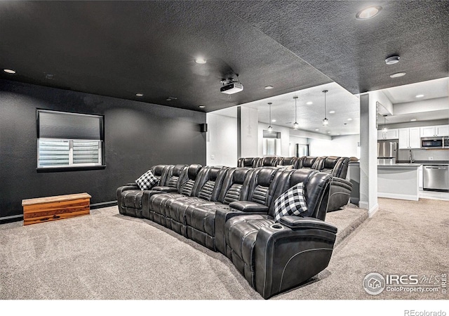home theater room with recessed lighting, baseboards, light carpet, and a sink