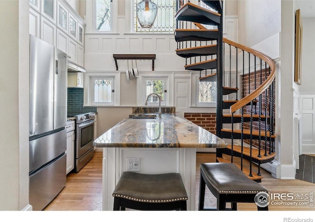 kitchen featuring light wood-style flooring, a wealth of natural light, appliances with stainless steel finishes, and a sink