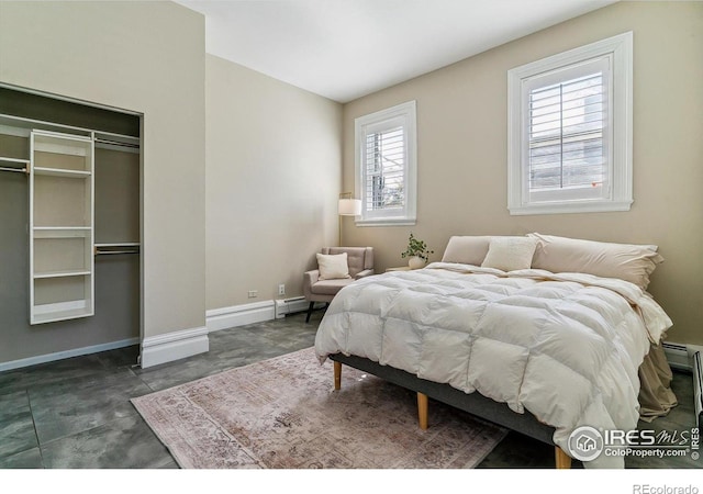 bedroom with baseboards, a closet, a baseboard radiator, and multiple windows