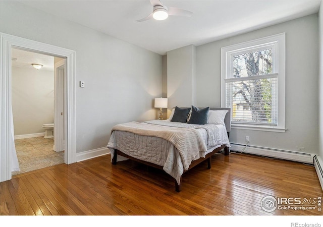 bedroom with baseboards, a ceiling fan, hardwood / wood-style floors, connected bathroom, and a baseboard radiator