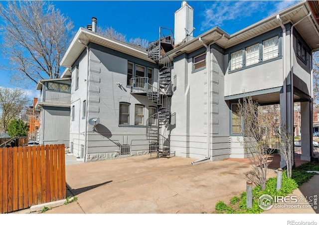 view of front of home with a chimney and fence