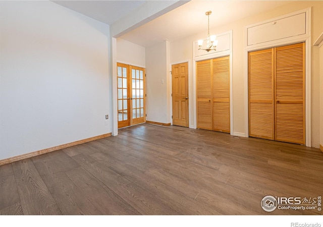 foyer featuring baseboards, french doors, wood finished floors, and a notable chandelier