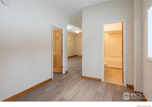 spare room featuring wood finished floors and baseboards