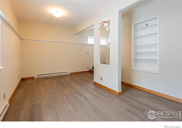 unfurnished room with baseboard heating, a baseboard radiator, baseboards, and wood finished floors