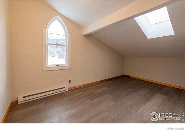 bonus room featuring baseboards, wood finished floors, a baseboard radiator, and vaulted ceiling with skylight