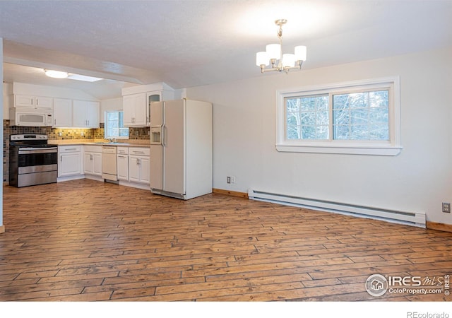 kitchen with white appliances, a wealth of natural light, a chandelier, and a baseboard radiator