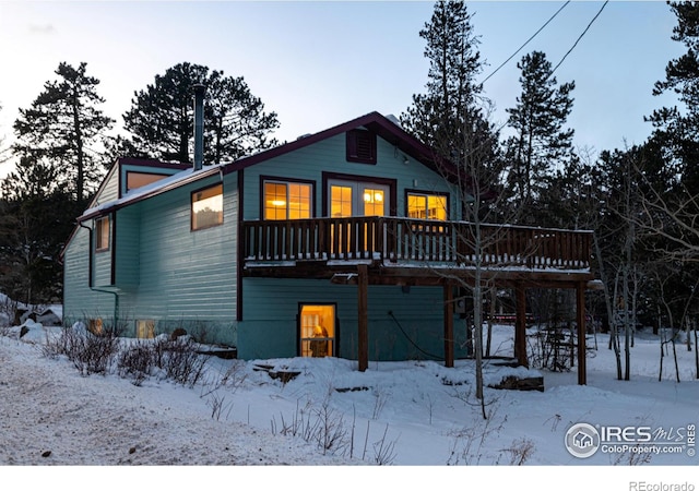 snow covered house with a deck