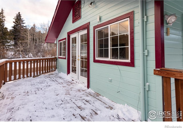 snow covered deck with french doors