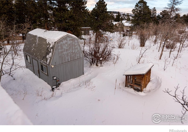 yard covered in snow featuring an outdoor structure and a barn
