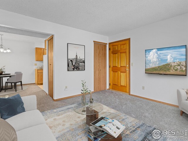 1155 S Saint Vrain Ave Unit 1-3, Estes Park, CO 80517 - living area with a chandelier, baseboards, carpet flooring, and a textured ceiling