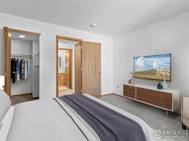 1155 S Saint Vrain Ave Unit 1-3, Estes Park, CO 80517 - carpeted bedroom featuring a textured ceiling, a closet, a walk in closet, ensuite bath, and baseboards