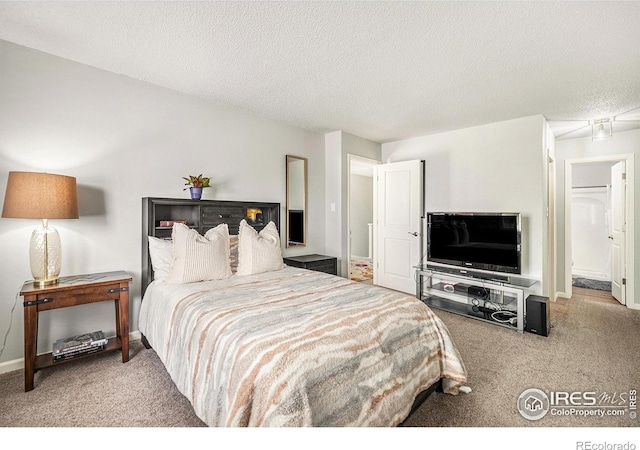 bedroom featuring baseboards, carpet flooring, and a textured ceiling