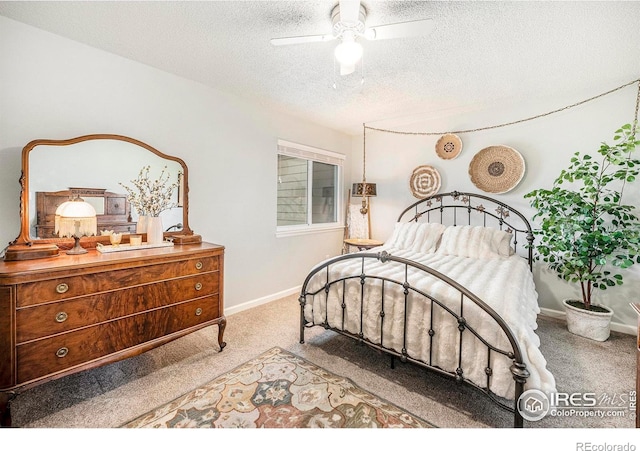 carpeted bedroom with baseboards, a ceiling fan, and a textured ceiling