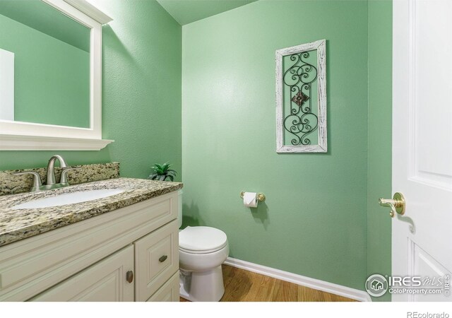 2225 Clayton Cir, Superior, CO 80027 - bathroom featuring baseboards, wood finished floors, toilet, and vanity