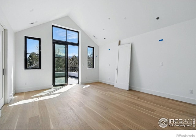 unfurnished room featuring vaulted ceiling, baseboards, visible vents, and light wood-style floors