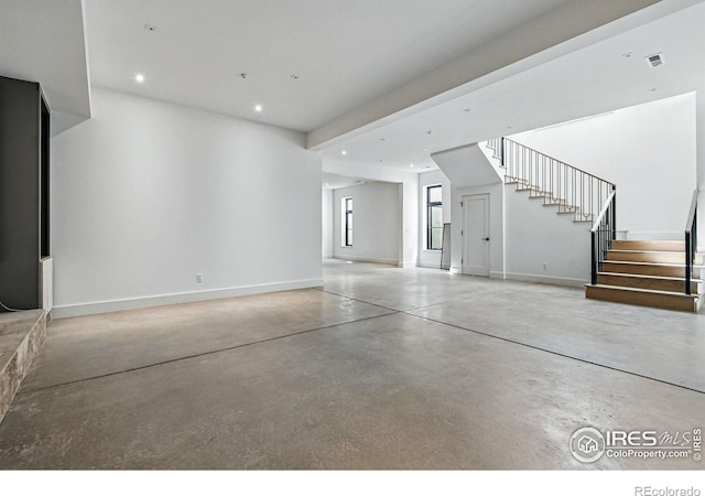unfurnished living room featuring finished concrete floors, stairs, visible vents, baseboards, and recessed lighting
