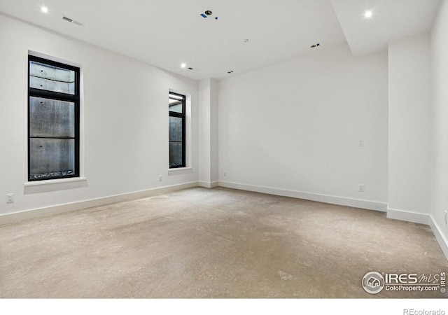 unfurnished room with visible vents, concrete flooring, baseboards, and recessed lighting