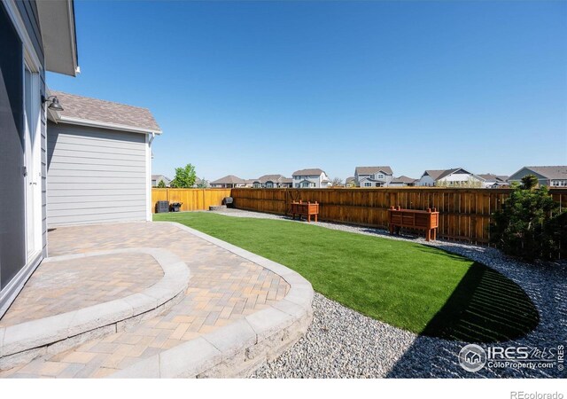 view of yard with a fenced backyard, a patio area, and a residential view