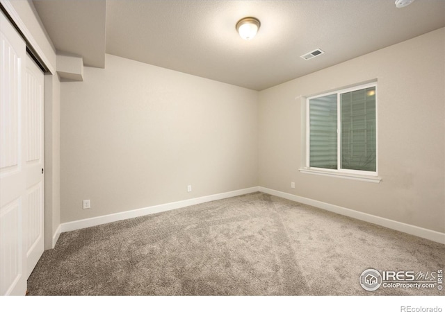 unfurnished bedroom with carpet flooring, baseboards, visible vents, and a closet