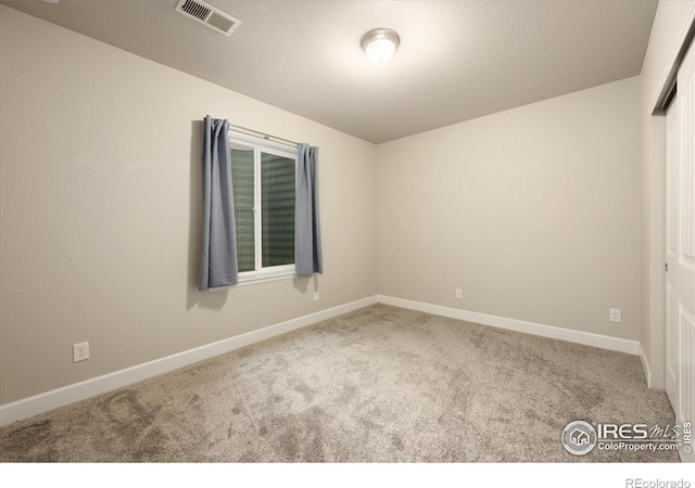 unfurnished bedroom with carpet flooring, baseboards, visible vents, and a closet