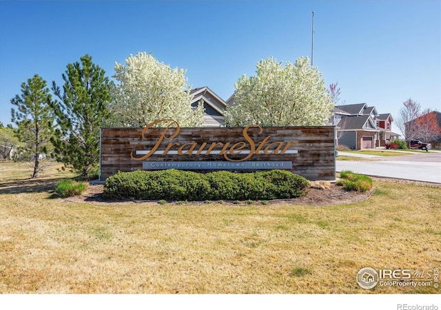 community sign featuring a yard and a residential view