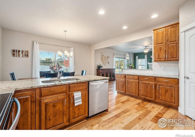 kitchen featuring dishwasher, light wood finished floors, brown cabinetry, and a sink