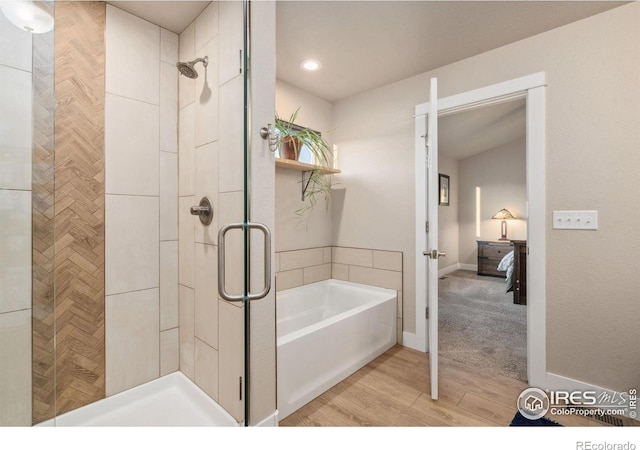 full bathroom with baseboards, a garden tub, wood finished floors, and a stall shower