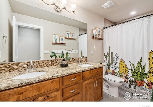 full bath featuring backsplash, double vanity, toilet, and a sink