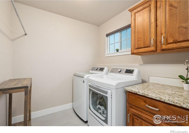laundry room featuring baseboards, washer and dryer, and cabinet space