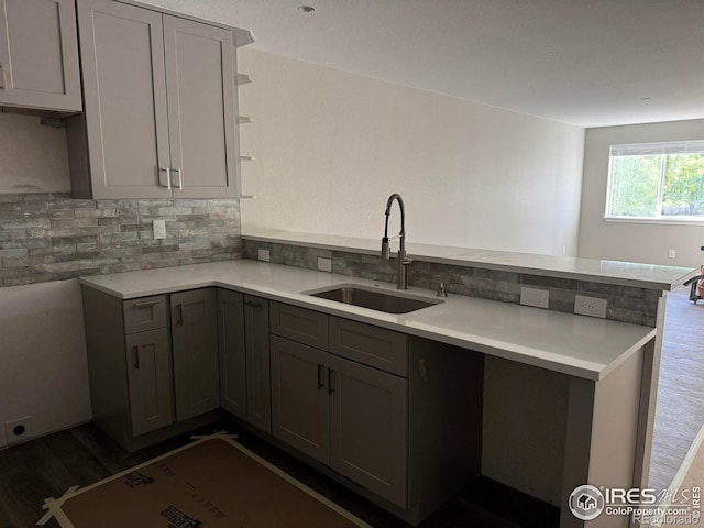 1687 Valency Dr, Loveland, CO 80537 - kitchen with a sink, gray cabinetry, open shelves, a peninsula, and backsplash