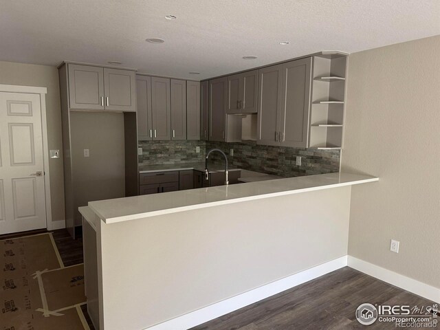 1687 Valency Dr, Loveland, CO 80537 - kitchen featuring gray cabinets, a sink, open shelves, backsplash, and a peninsula